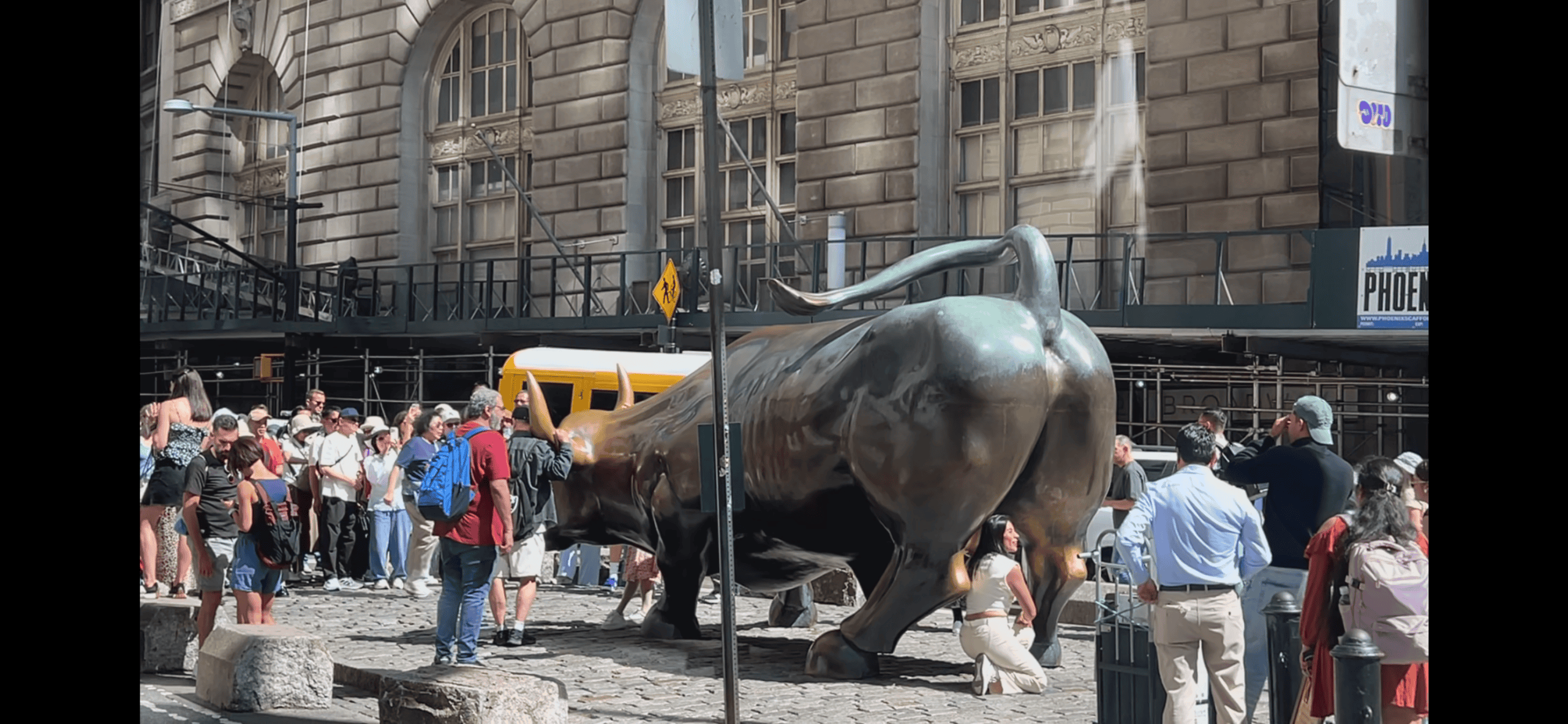 People gathering around the Charging Bull statue on Wall Street in New York